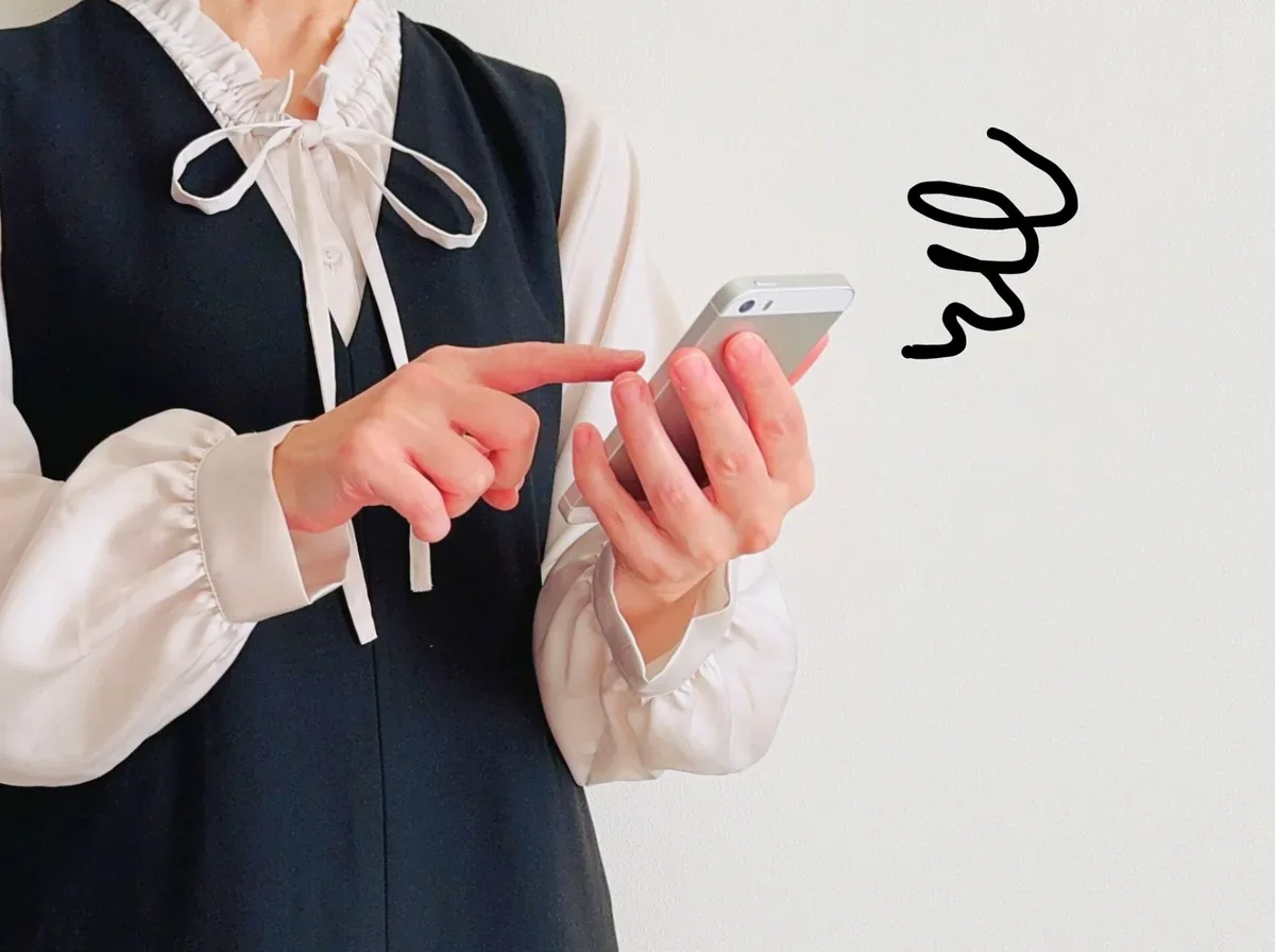 屋外でスマートフォンの通信に困る女性