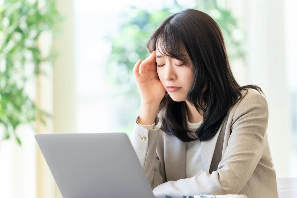 明るい室内でノートパソコン画面を確認する女性